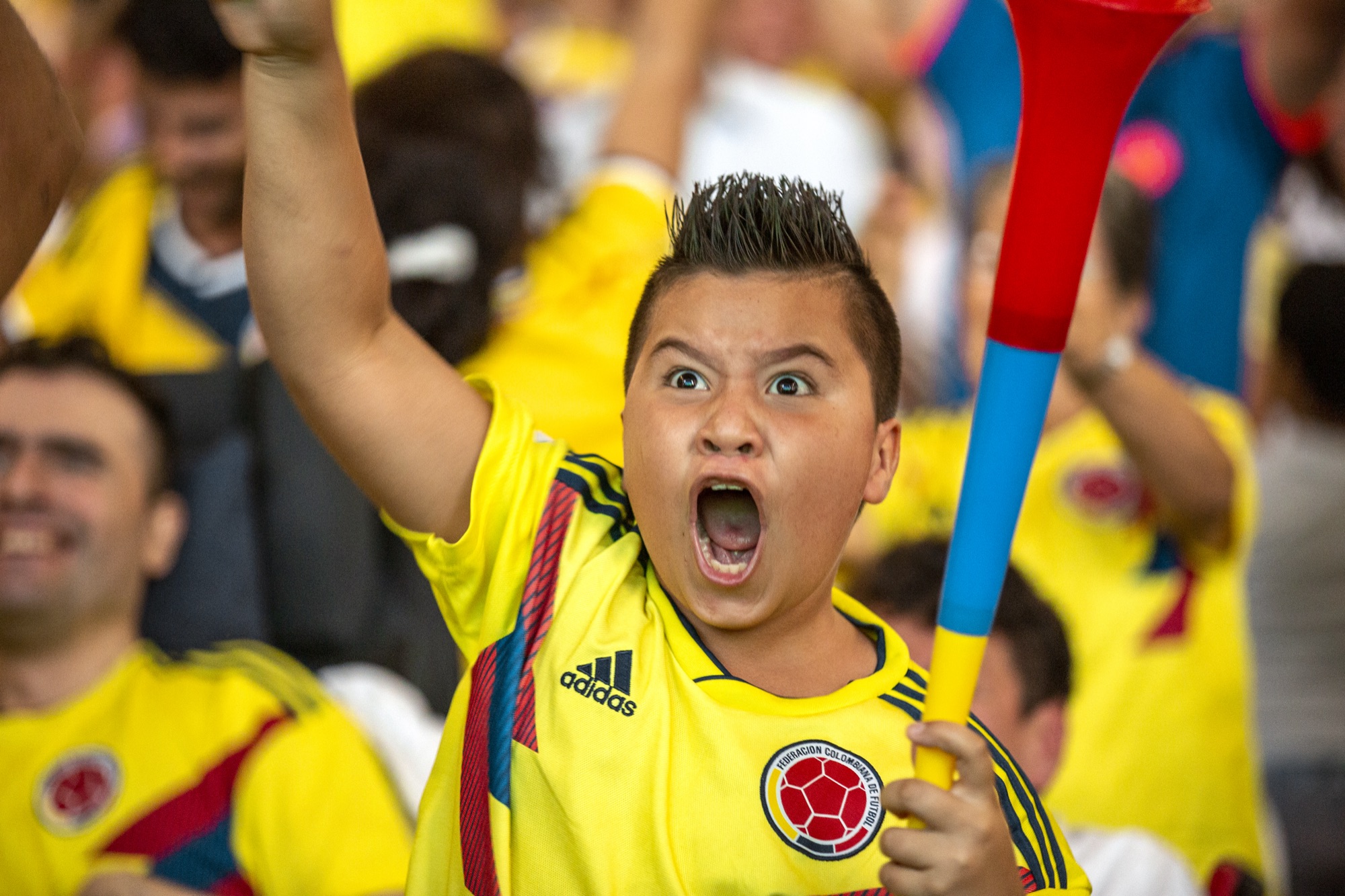 A young fan cheering for Colombia during the World Cup